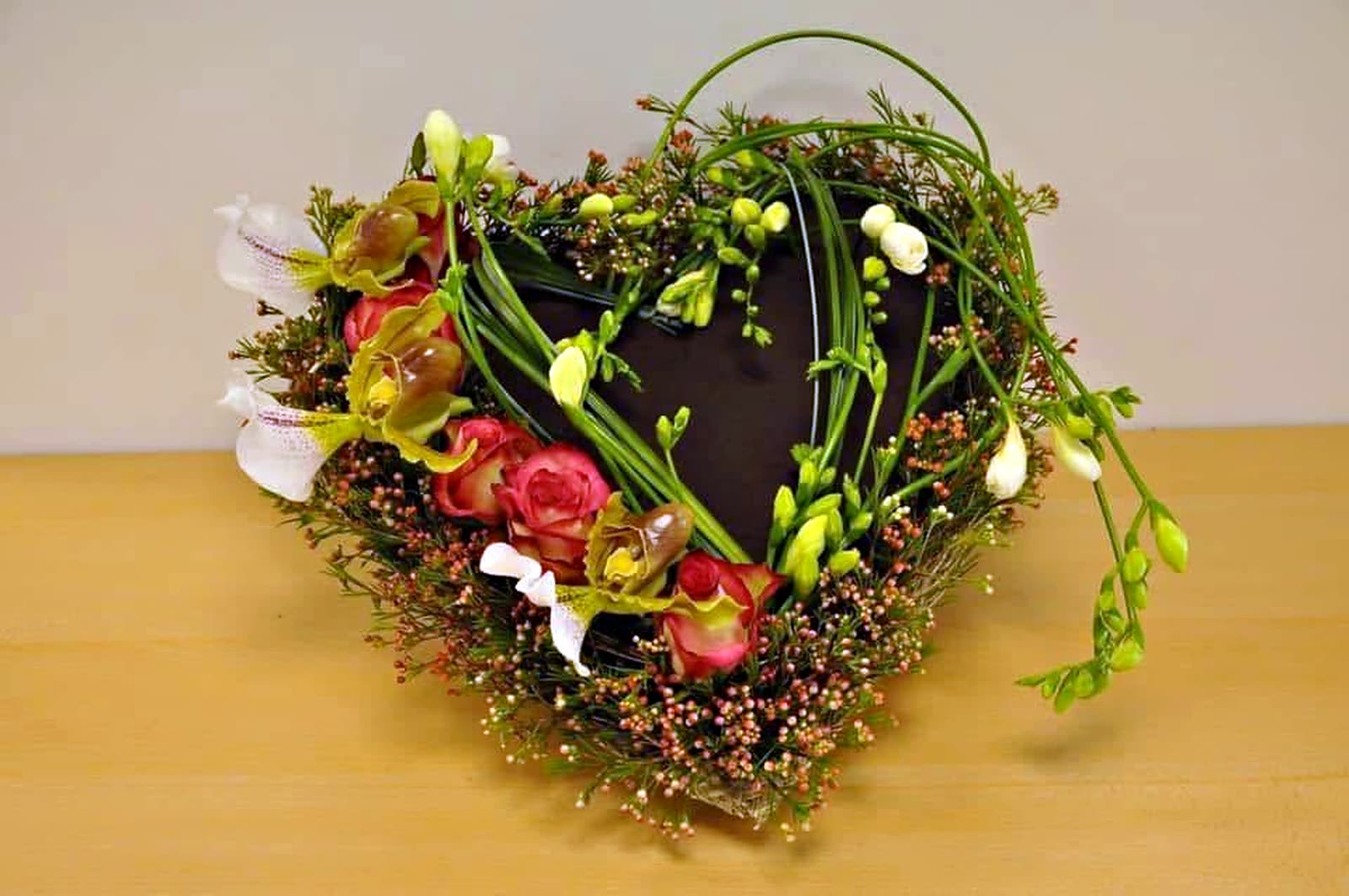 Heart-shaped sympathy wreath of moss, berries and blooms