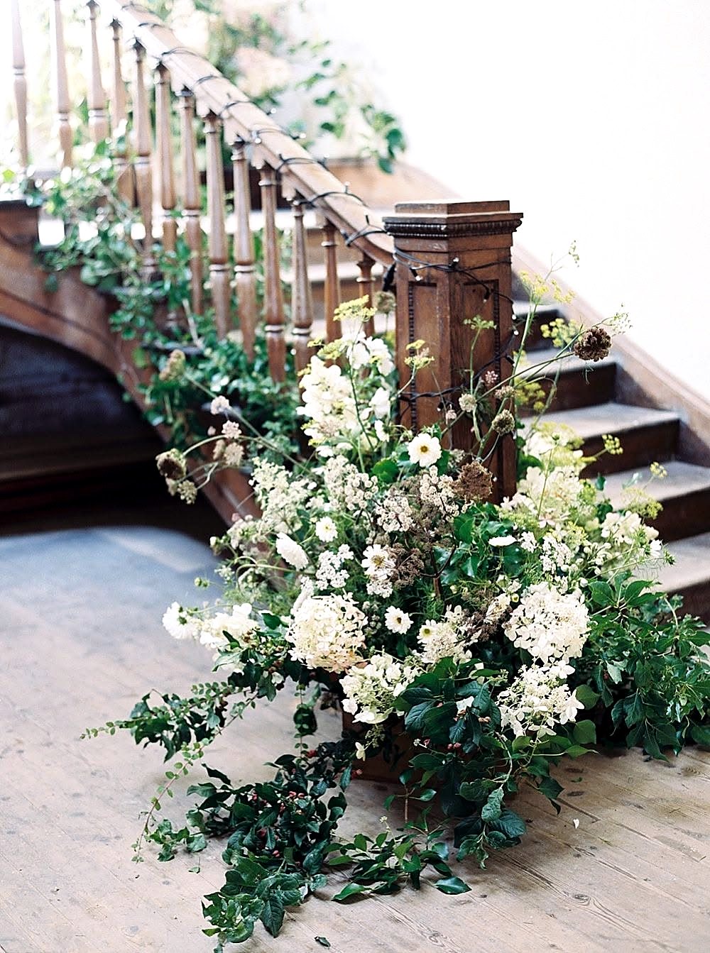 White blooms and trailing greenery along a staircase